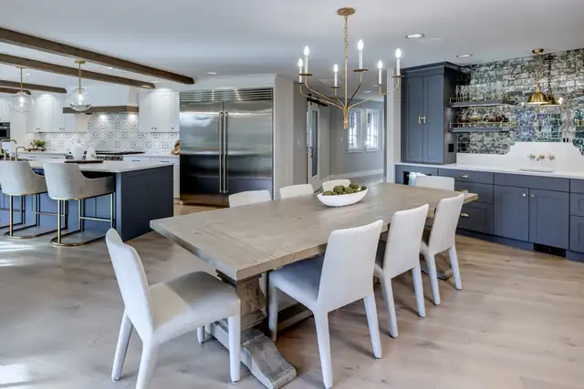 Medina whole-home remodel with a dining addition, long farmhouse table, navy cabinetry and an open kitchen beyond