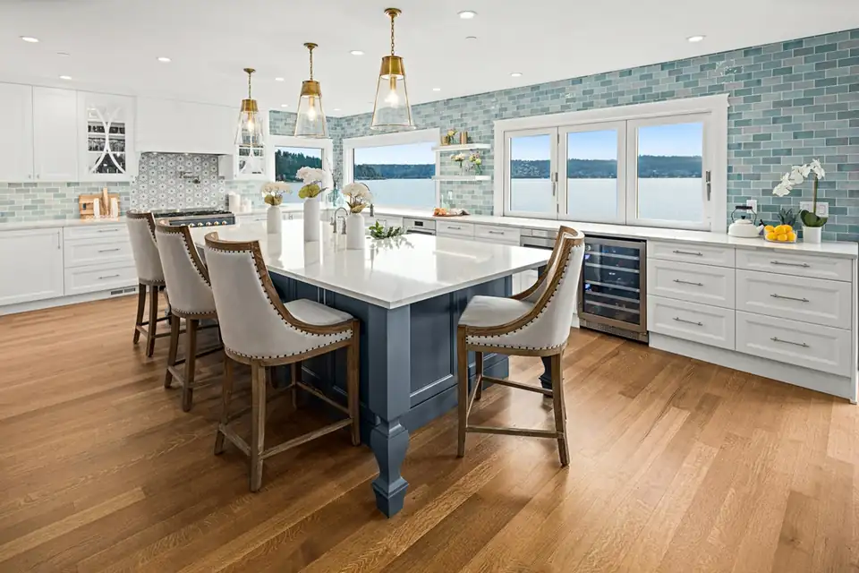 Kitchen remodeling Bellevue: lakeview kitchen with a navy island, white counters, blue glass tile backsplash and oak floors